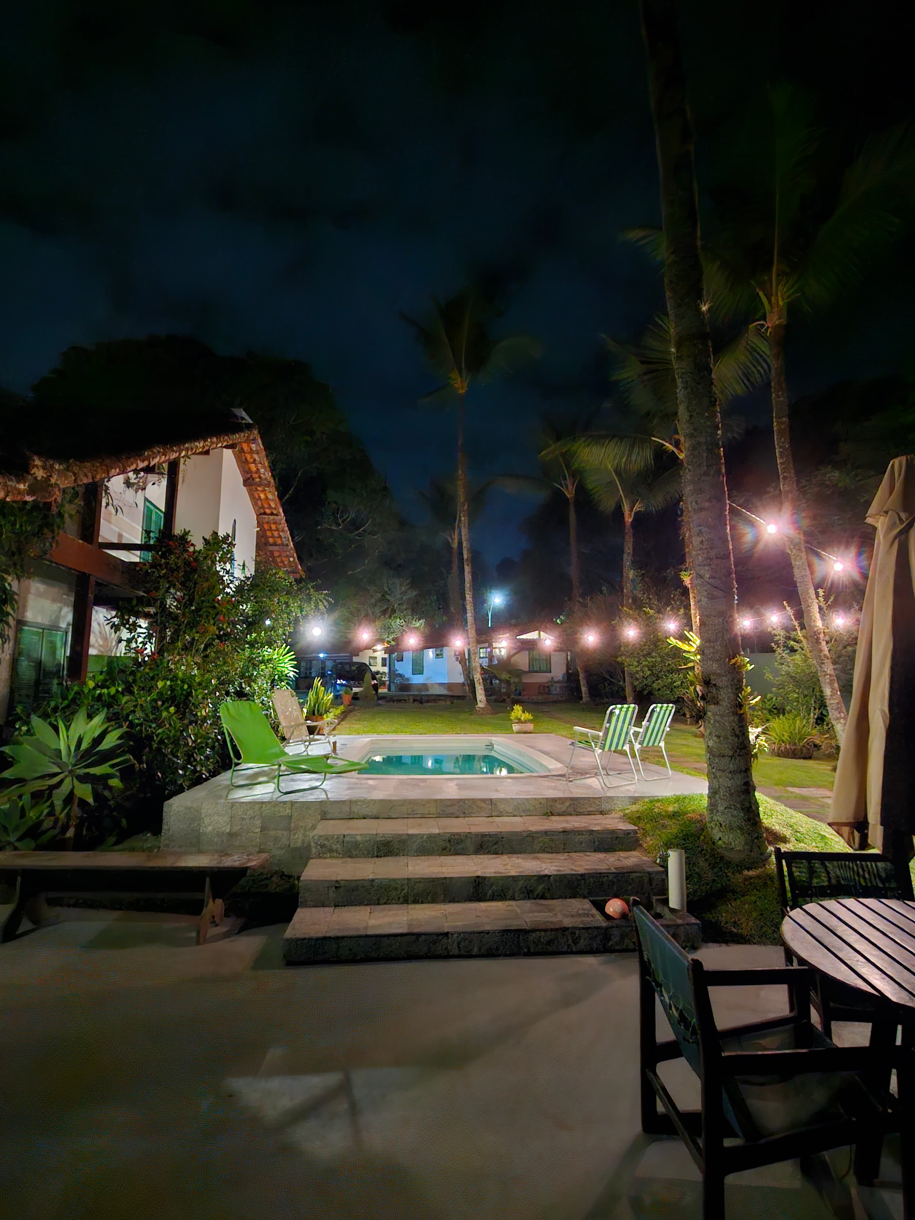 Piscina e jardim iluminados à noite